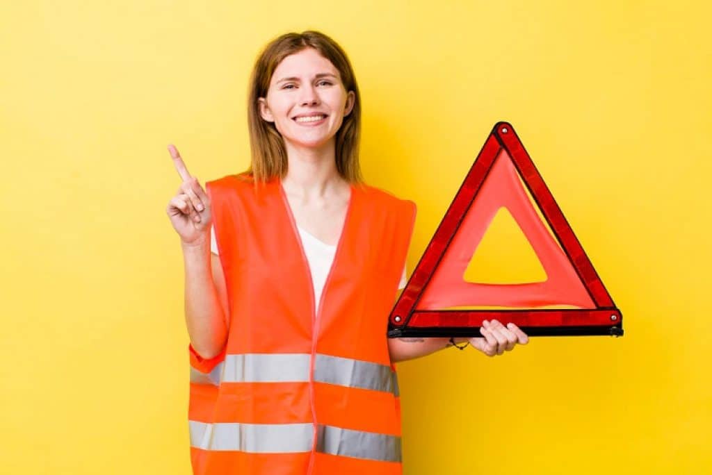 אישה מחזיקה שלט משולש בצבע אדום של בטיחות